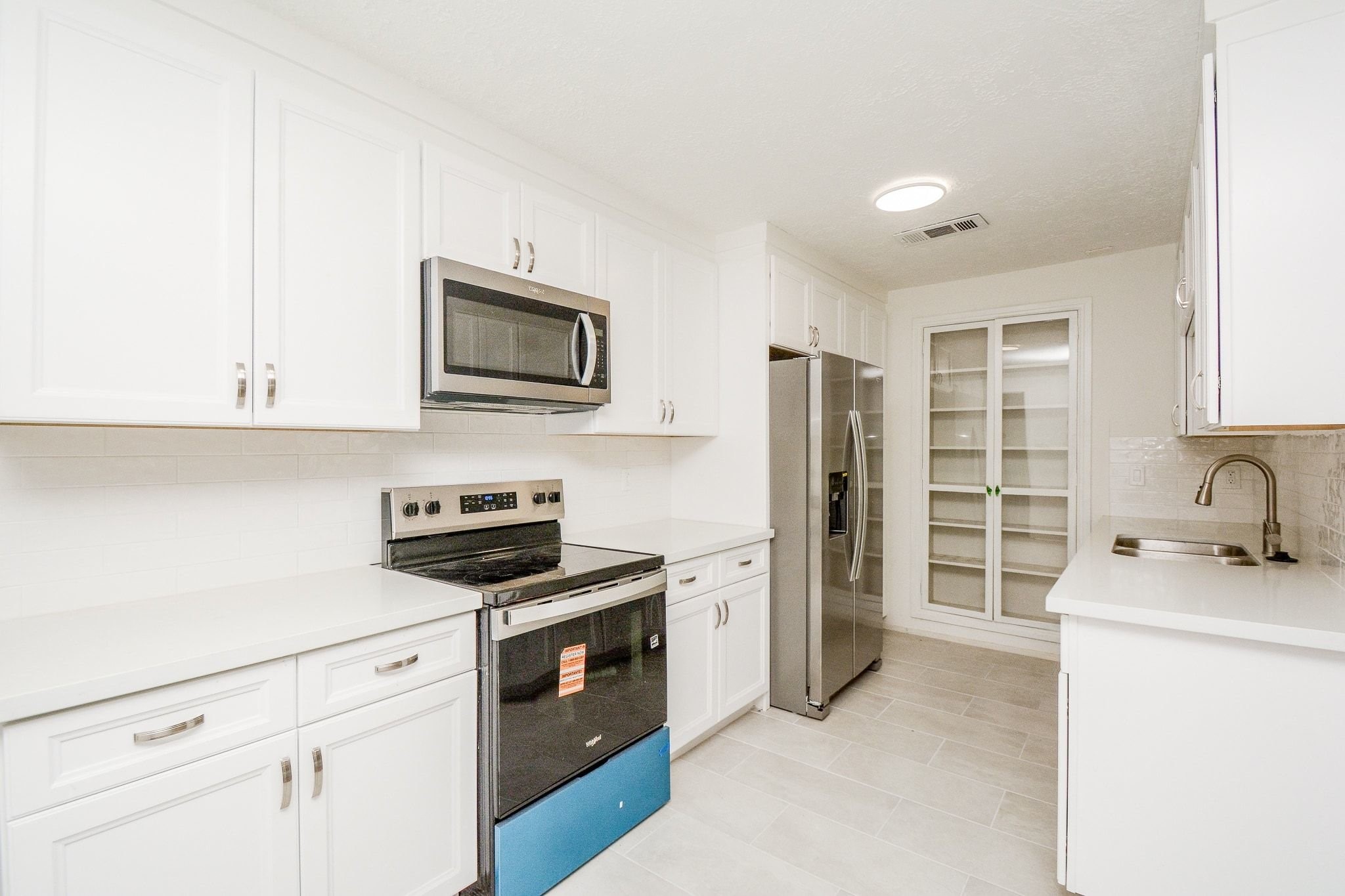 4307 Sloangate Drive Spring, TX 77373 - Photo 6 of 22 a kitchen with stainless steel appliances white cabinets and a stove top oven