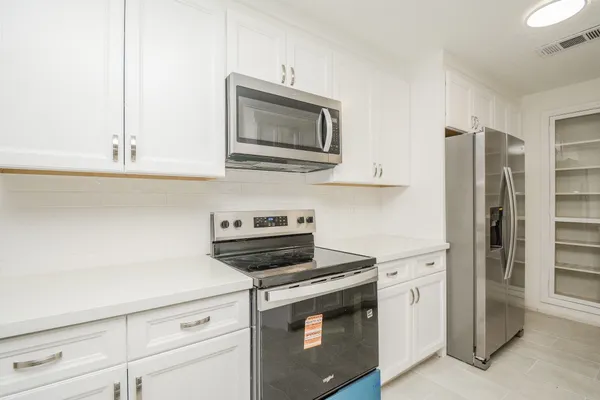 a kitchen with stainless steel appliances a stove microwave and refrigerator