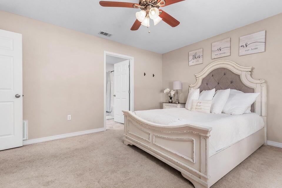 102 Lear Court Crestview, FL 32539 - Photo 20 of 37 a spacious bedroom with a bed and a chandelier