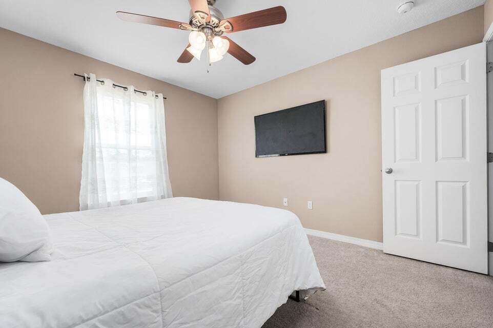 102 Lear Court Crestview, FL 32539 - Photo 28 of 37 a bedroom with a large bed and a flat screen tv