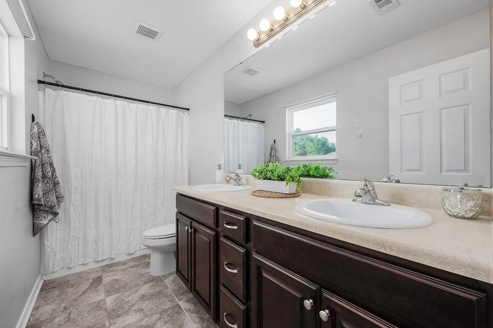 102 Lear Court Crestview, FL 32539 - Photo 30 of 37 a bathroom with a granite countertop sink a toilet and a mirror