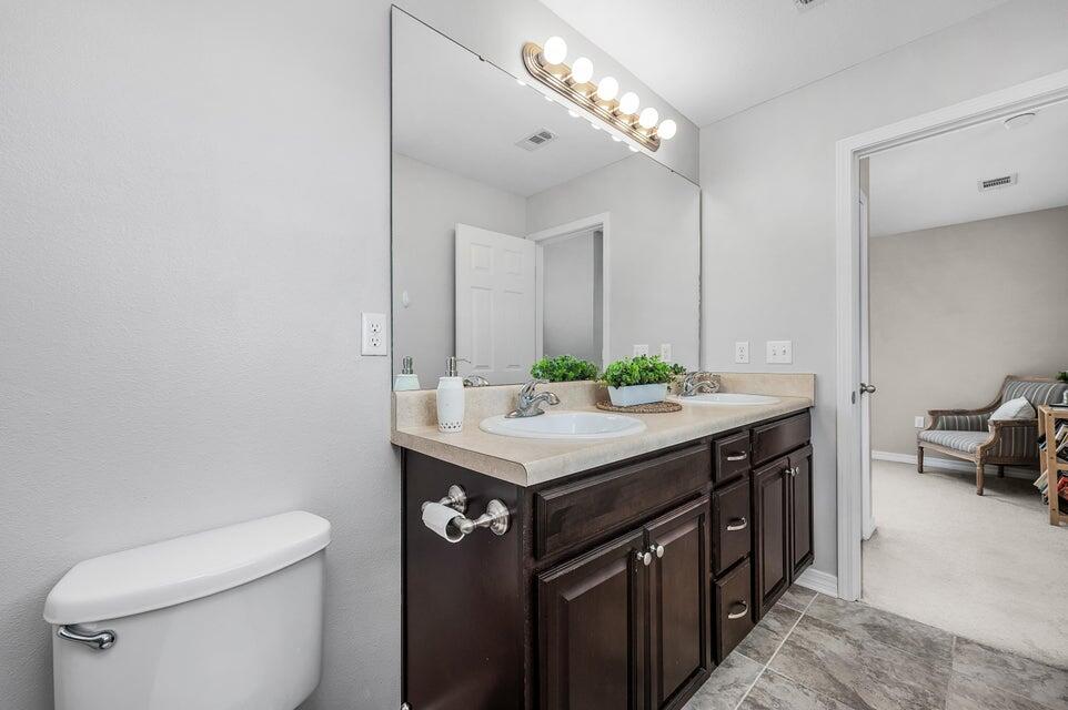 102 Lear Court Crestview, FL 32539 - Photo 31 of 37 a bathroom with a granite countertop sink a toilet and a mirror