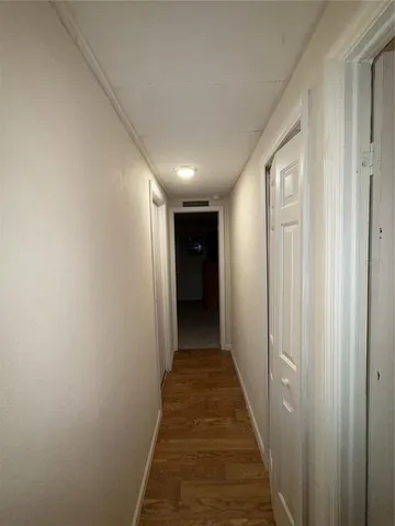 a view of hallway with wooden floor