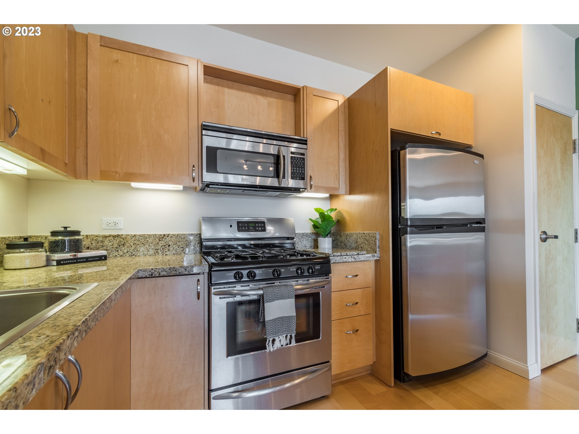 1375 Olive Street, Unit 308 Eugene, OR 97401 - Photo 15 of 35 a kitchen with stainless steel appliances granite countertop a refrigerator stove and microwave