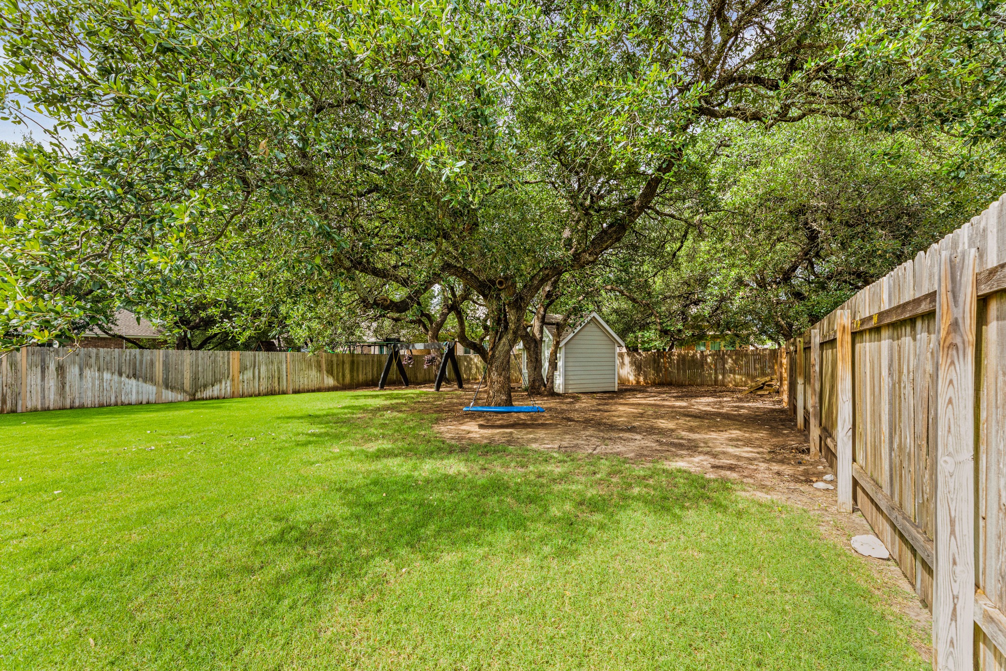 108 Redtail Lane Leander, TX 78641 - Photo 28 of 39 A spacious, fenced backyard offers both lush green lawn and shade.