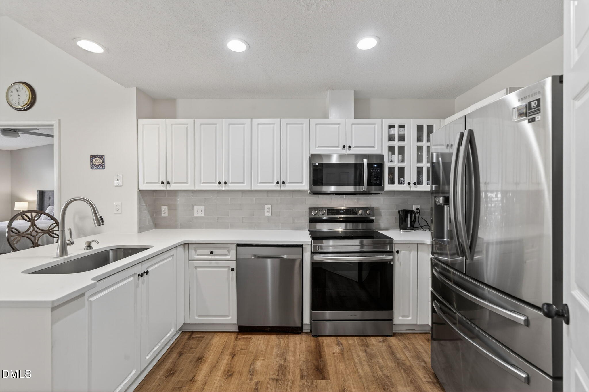 1911 Falls Landing Drive, Unit 203 Raleigh, NC 27614 - Photo 15 of 39 a kitchen with white cabinets stainless steel appliances and a refrigerator