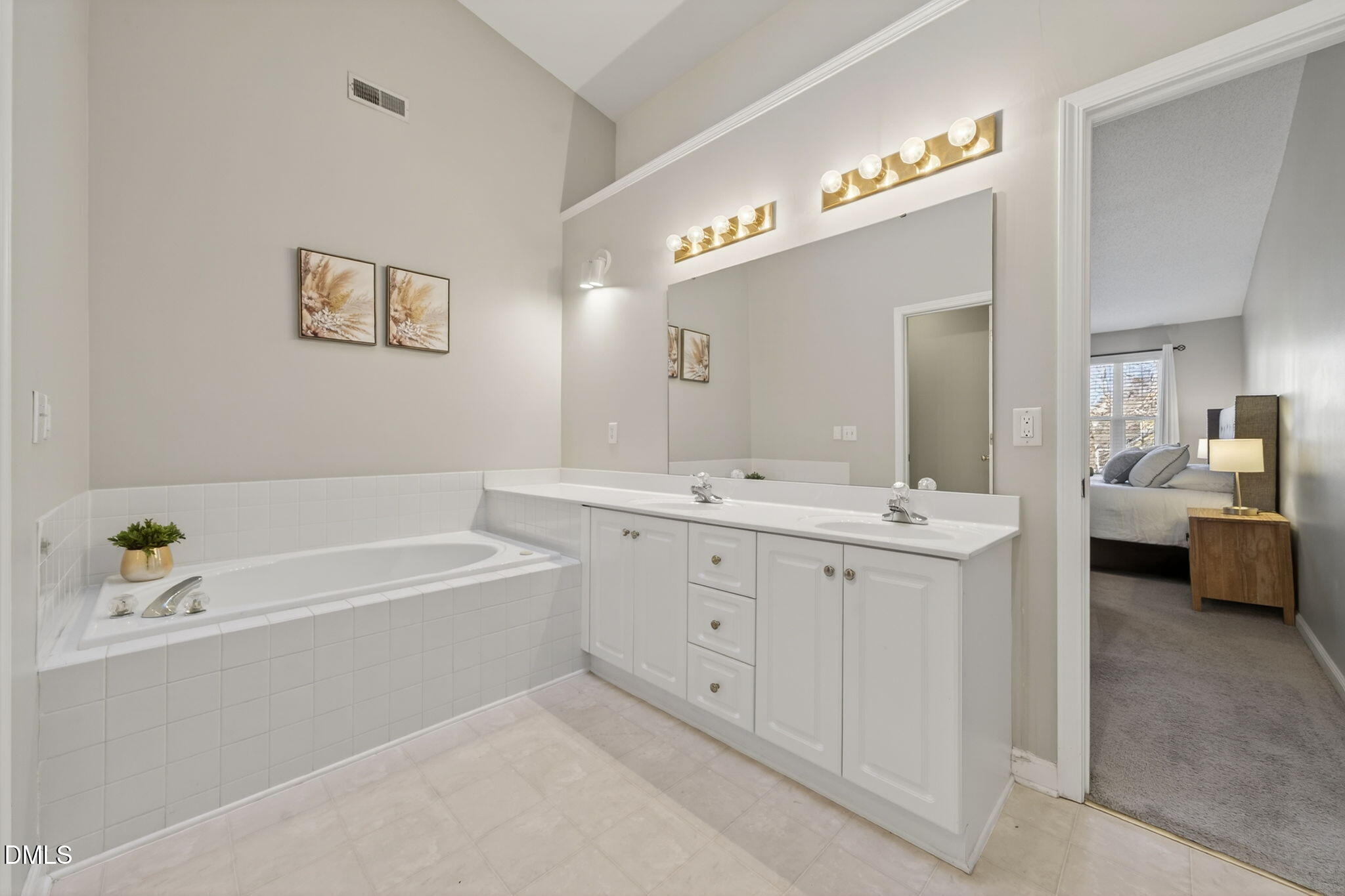 1911 Falls Landing Drive, Unit 203 Raleigh, NC 27614 - Photo 25 of 39 a spacious bathroom with a double vanity sink a mirror a bathtub and next to a window