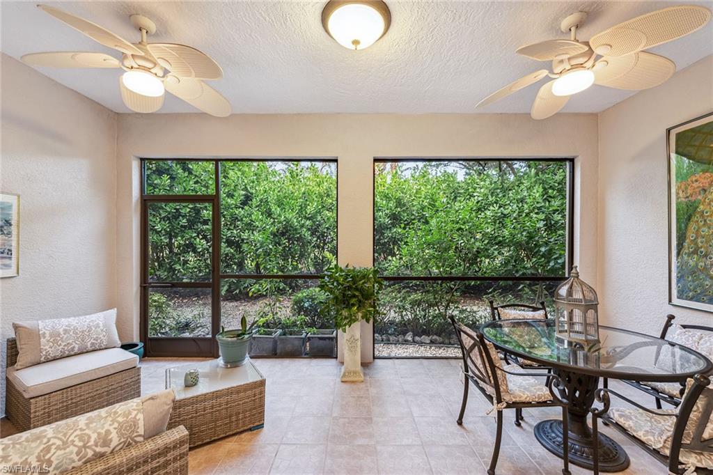3985 Deer Crossing Court, Unit 103 Naples, FL 34114 - Photo 15 of 37 a living room with furniture and a large window
