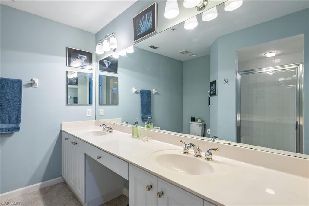 3985 Deer Crossing Court, Unit 103 Naples, FL 34114 - Photo 9 of 37 a bathroom with a sink double vanity granite and a mirror