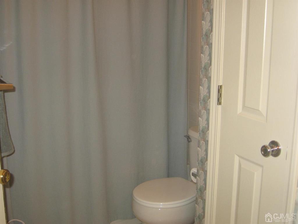 1708 Ridgeview Court Sayreville, NJ 08859 - Photo 19 of 24 a white toilet sitting next to a shower curtain