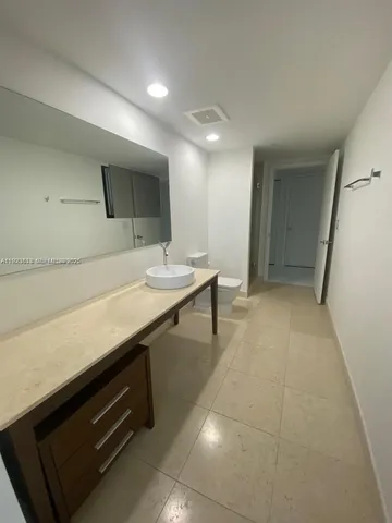 a hallway with a large counter top space and cabinets