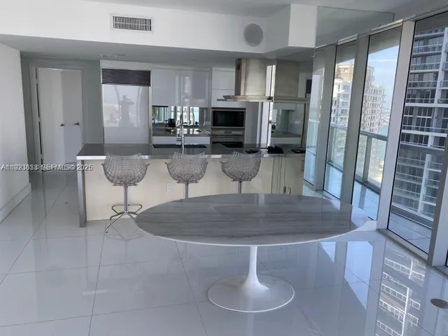 an open kitchen with dining table and chairs