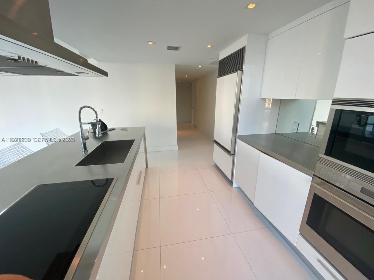495 Brickell Avenue, Unit 2902 Miami, FL 33131 - Photo 9 of 31 a kitchen with a sink and a stove top oven