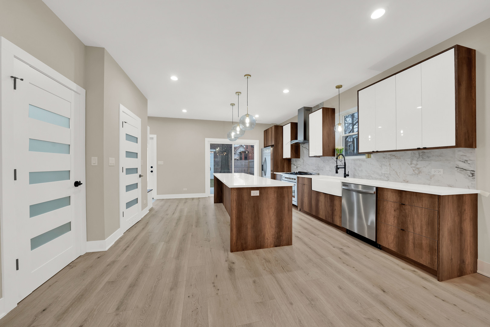 5901 West Erie Street Chicago, IL 60644 - Photo 11 of 38 a large kitchen with a center island wooden floor stainless steel appliances and a window