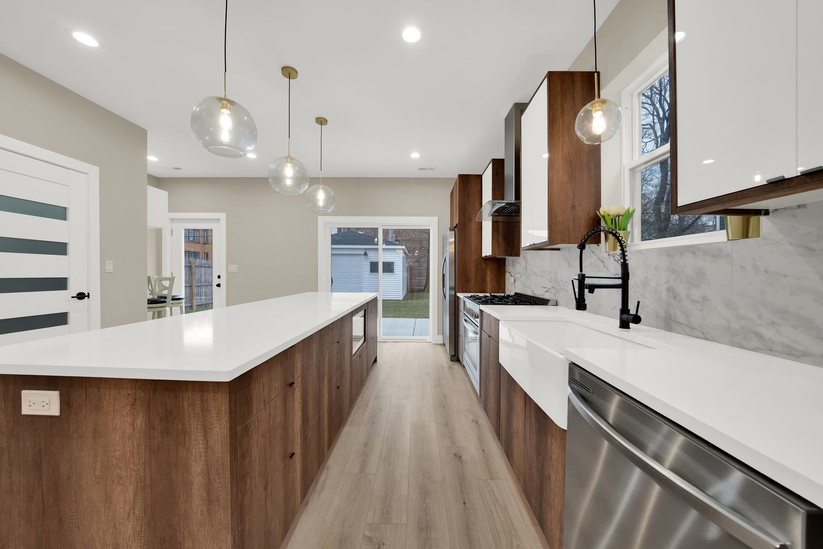 5901 West Erie Street Chicago, IL 60644 - Photo 13 of 38 a large kitchen with stainless steel appliances a large counter top a refrigerator a sink and a stove