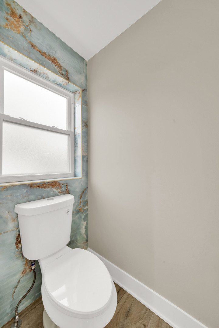 5901 West Erie Street Chicago, IL 60644 - Photo 25 of 38 a white toilet sitting next to a window