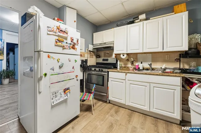a kitchen with white cabinets and white appliances