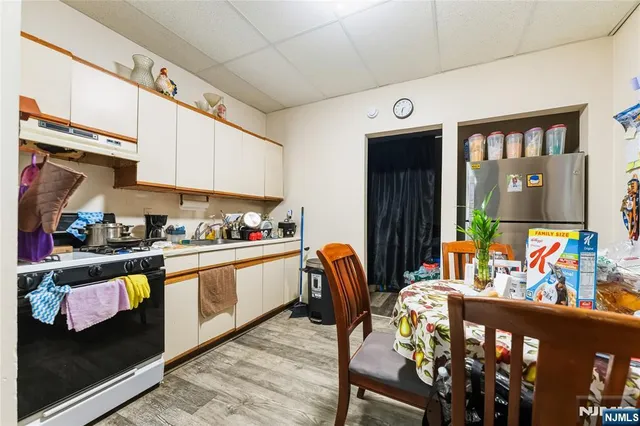 a kitchen with stainless steel appliances granite countertop a refrigerator and a dining table