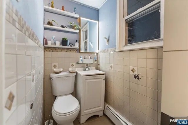 a white toilet sitting next to a bathroom sink and a mirror