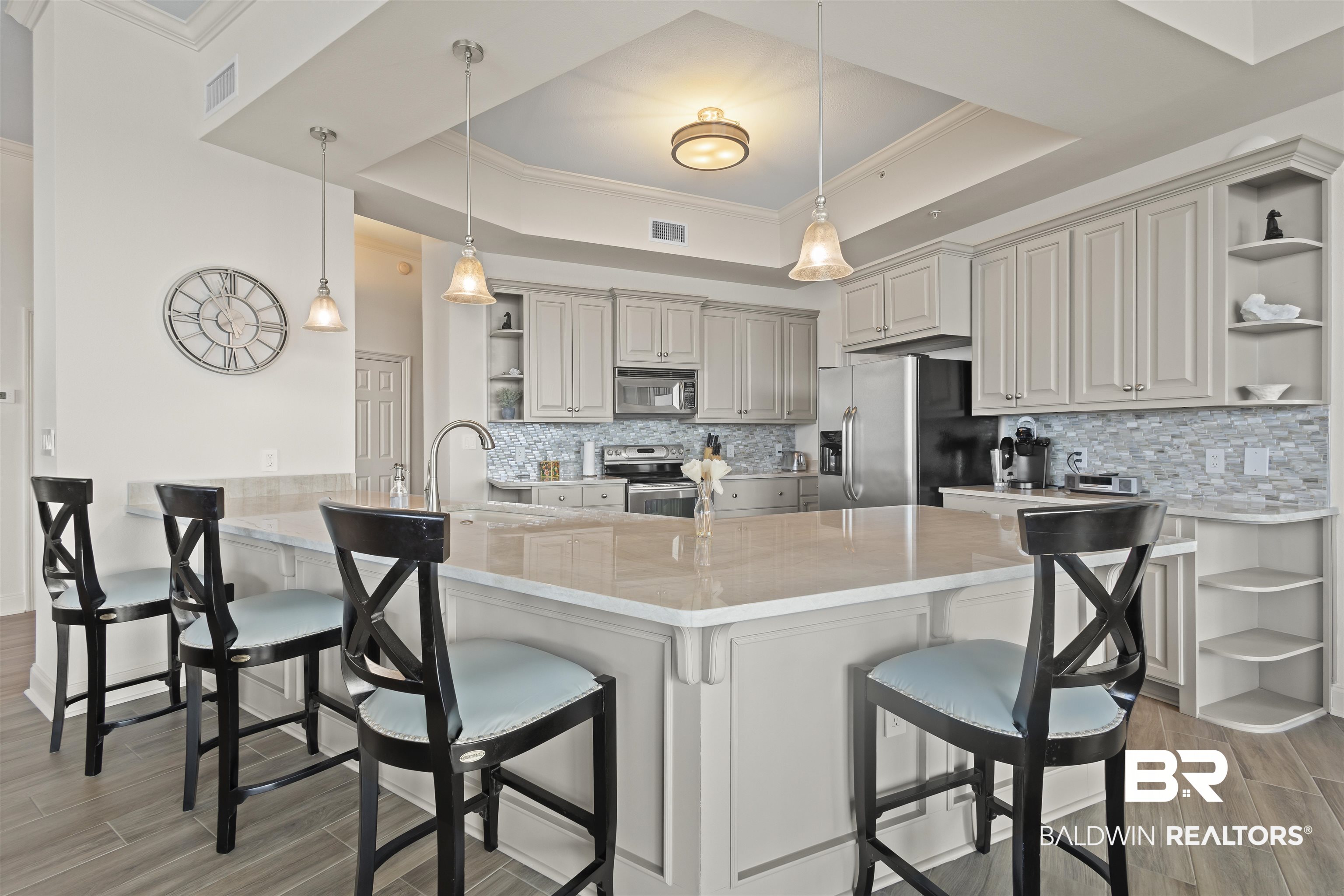 27800 Canal Road, Unit 120 Orange Beach, AL 36561 - Photo 7 of 68 Kitchen with kitchen peninsula, a kitchen breakfast bar, stainless steel appliances, and a raised ceiling