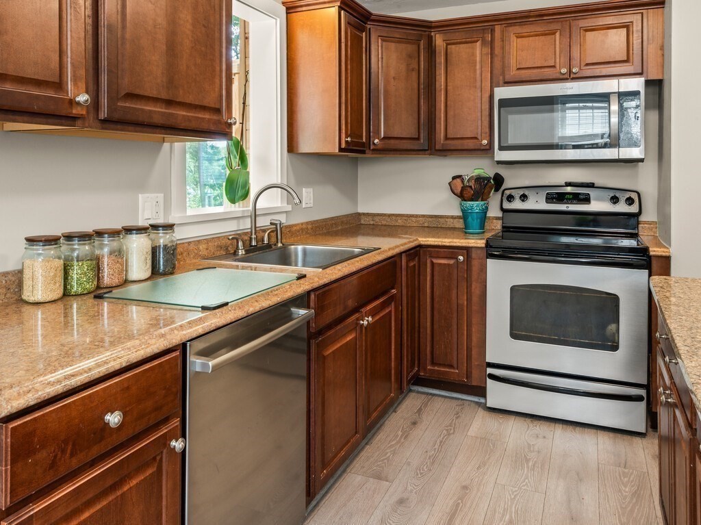 27 Whitla Drive Worcester, MA 01604 - Photo 7 of 38 a kitchen with stainless steel appliances granite countertop a sink stove and microwave