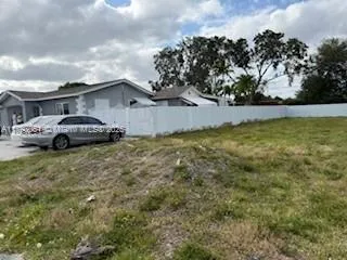 a car parked in front of a house with a yard