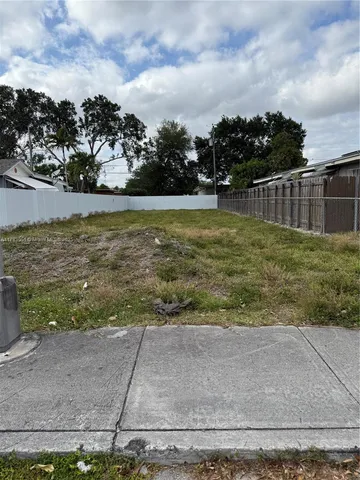 a view of a yard with wooden fence