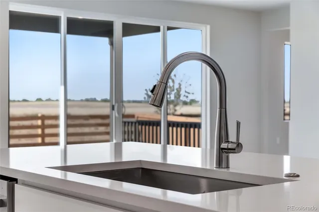 a kitchen with granite countertop white cabinets and stainless steel appliances