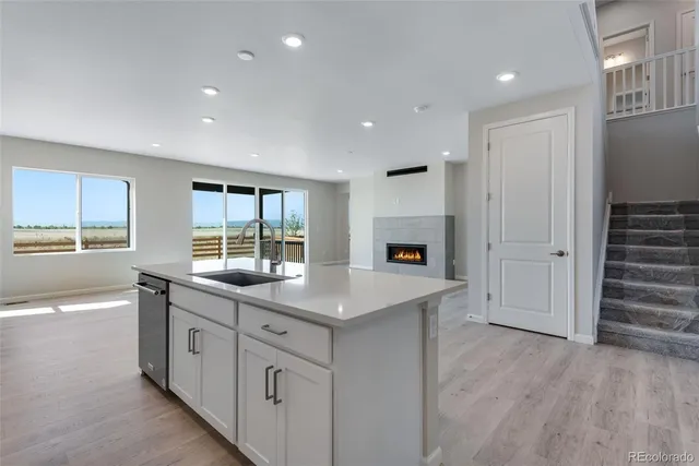 a kitchen with white cabinets and window