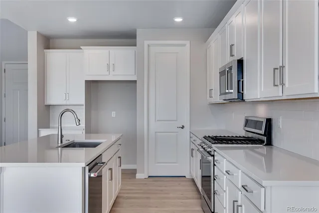 a kitchen with granite countertop a sink stove and cabinets