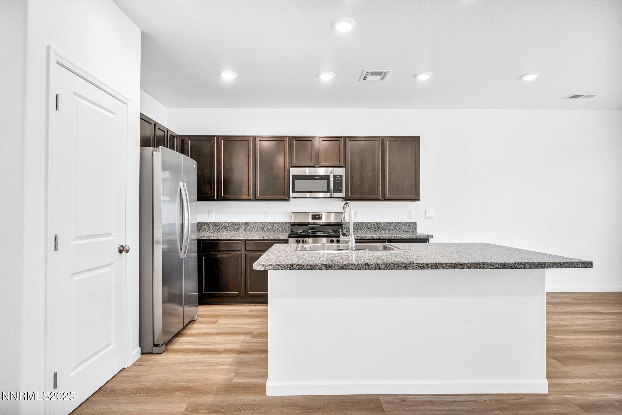 700 Kess Way Reno, NV 89506 - Photo 43 of 53 a kitchen with stainless steel appliances granite countertop a refrigerator a stove and a sink with wooden cabinets