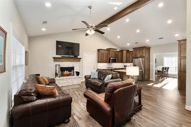 a living room with furniture a flat screen tv and a fireplace