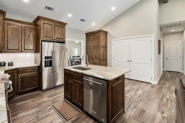 a kitchen with stainless steel appliances a refrigerator and a stove top oven