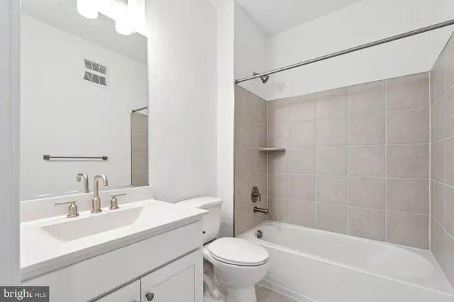 a bathroom with a shower sink vanity and mirror