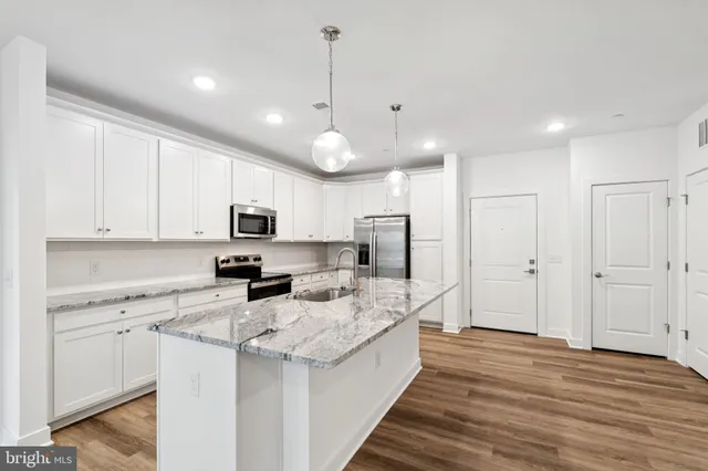 a large kitchen with kitchen island white cabinets and stainless steel appliances