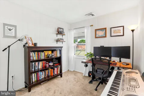 a view of a workspace with a bookshelf and a window