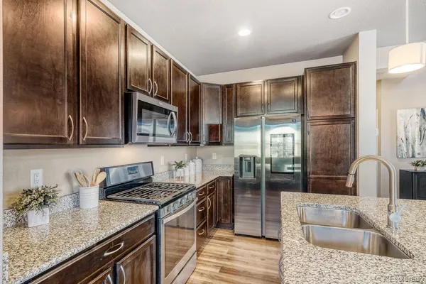 a kitchen with stainless steel appliances granite countertop a sink a stove and a refrigerator
