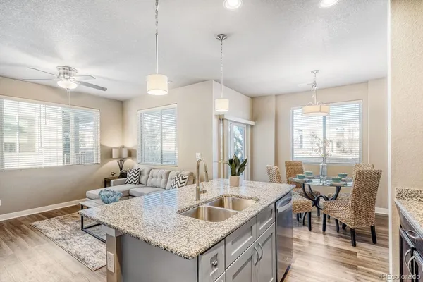 a kitchen with granite countertop a sink a counter space dining table and chairs