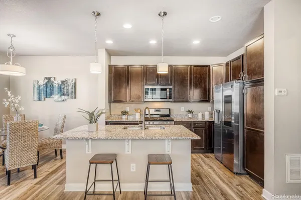 a kitchen with kitchen island granite countertop a sink cabinets and stainless steel appliances