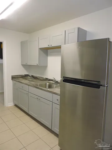 a kitchen with a refrigerator sink and cabinets