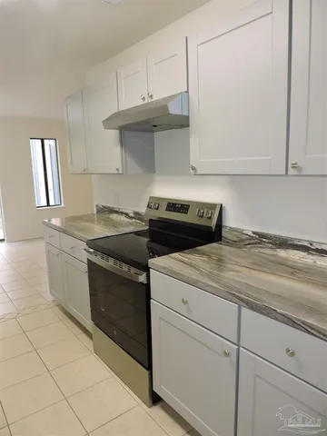 a kitchen with a stove cabinets and a sink