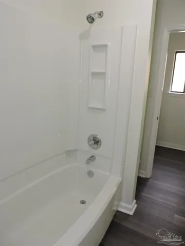 a white bath tub sitting next to a shower