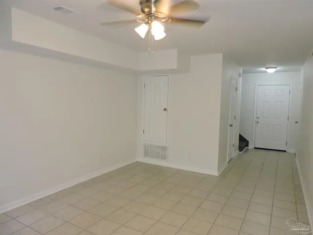 an empty room with closet and a chandelier fan
