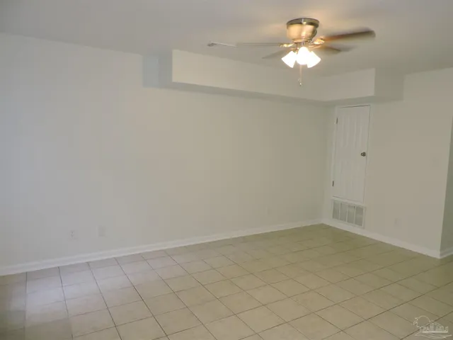 an empty room with a ceiling fan and a window