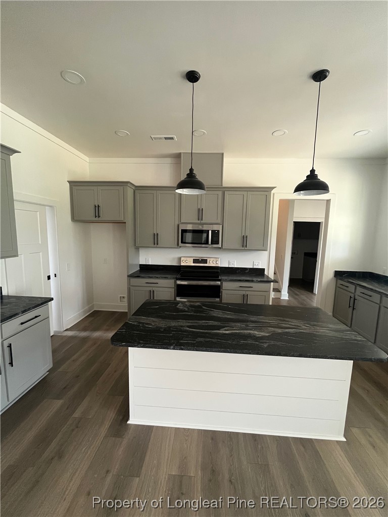 115 Keyser Street Aberdeen, NC 28315 - Photo 6 of 17 a view of kitchen and empty room with wooden floor