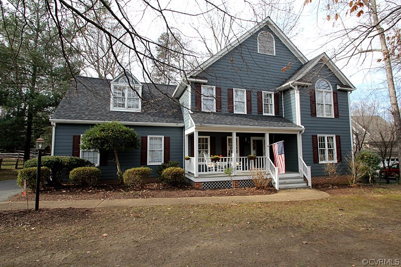 a front view of a house with backyard and trees