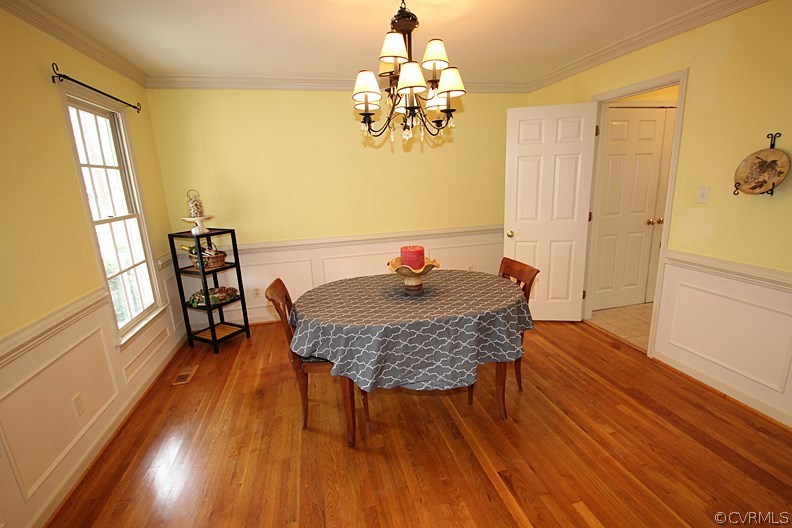 5708 Sandstone Ridge Terrace Midlothian, VA 23112 - Photo 5 of 23 a dining room with furniture a chandelier and wooden floor
