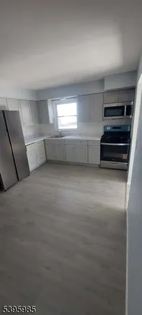 a view of empty room with wooden floor and windows
