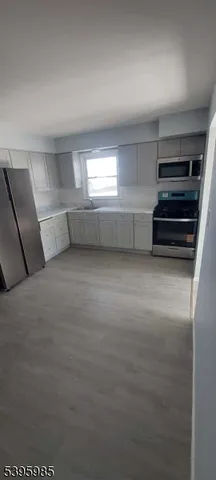 a view of empty room with wooden floor and windows