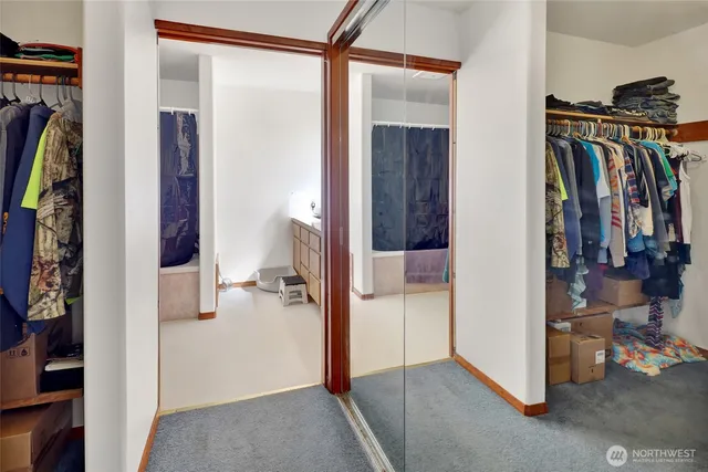 a view of walk in closet with clothes and shoes